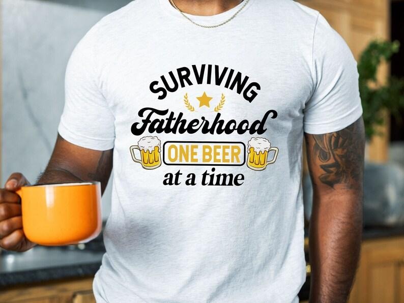 Surviving Fatherhood One Beer Time Funny Father - Adult & Kids T-Shirts, Sweatshirts & Hoodies apparel design preview 1